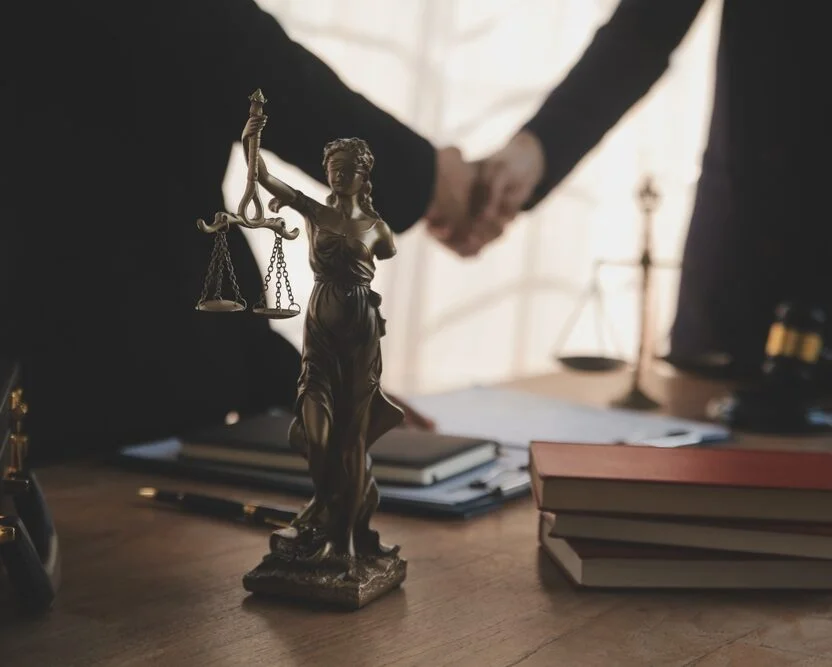 Lawyers meeting at a law firm with scales of justice and legal documents during a professional legal services consultation.