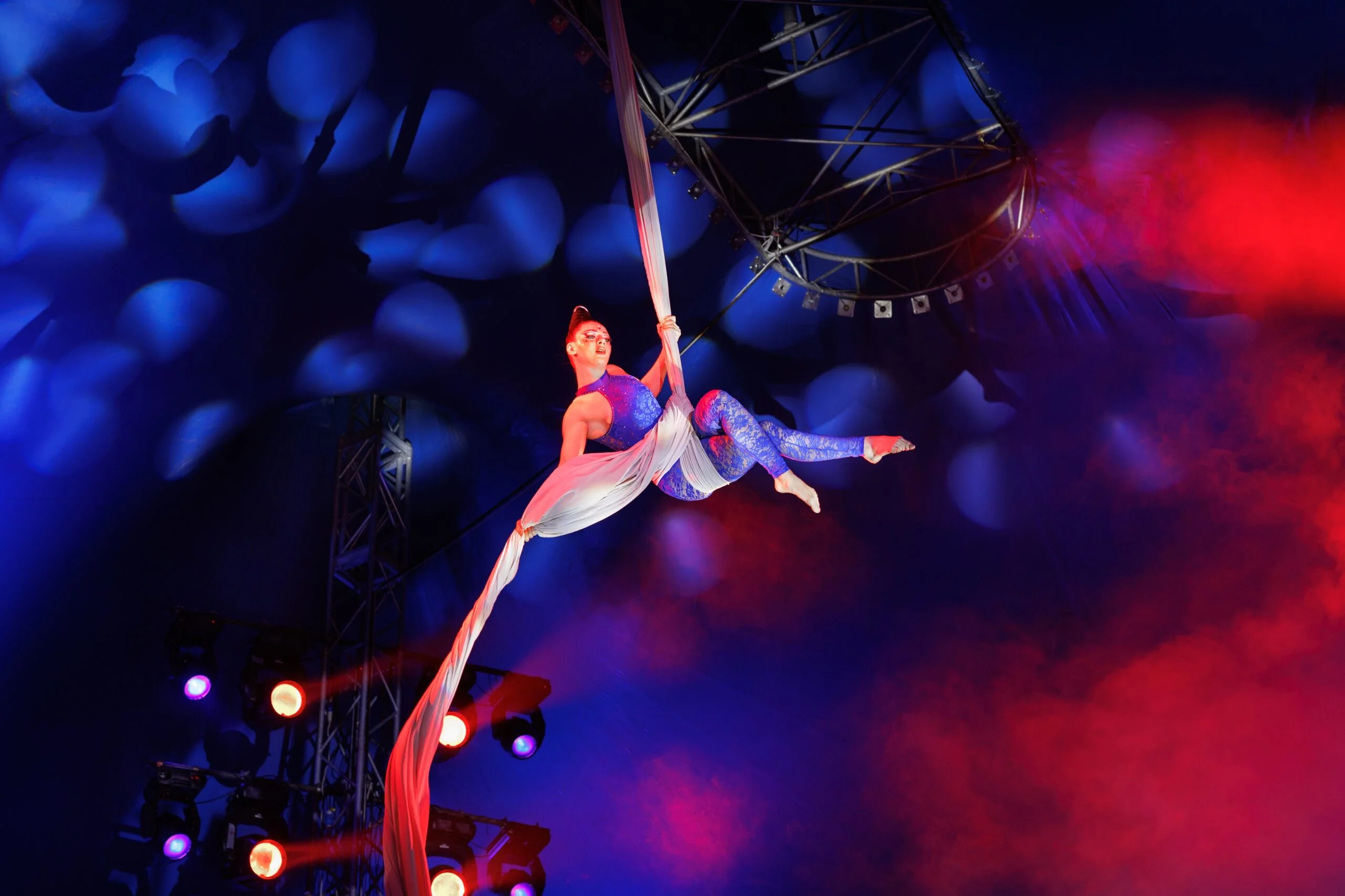 Aerialist performs a dangerous trick on a fabric high under