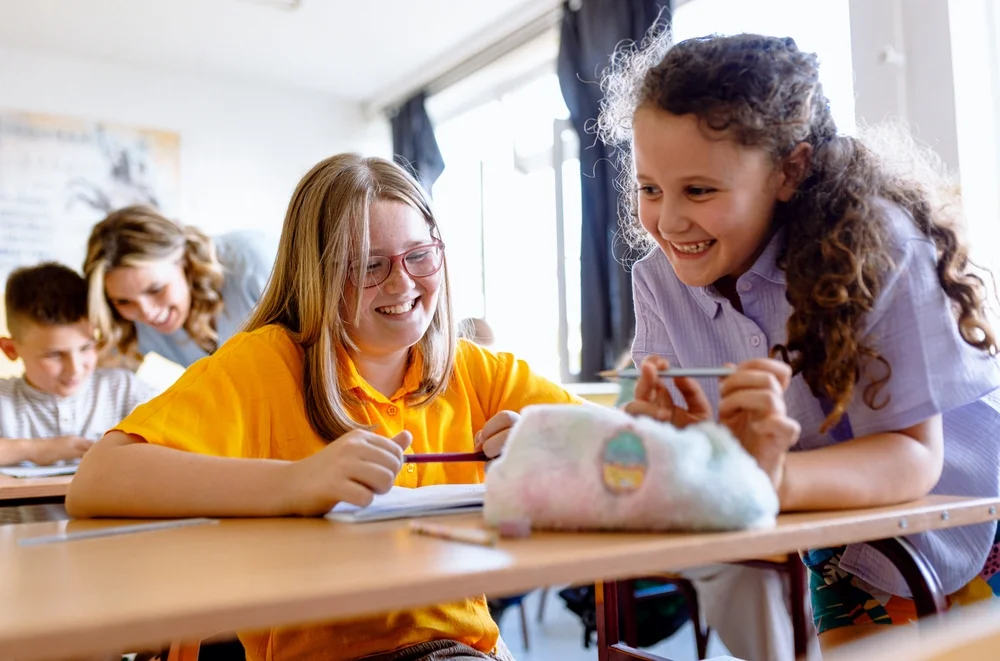 Portrait of girls sitting in school bench and writing