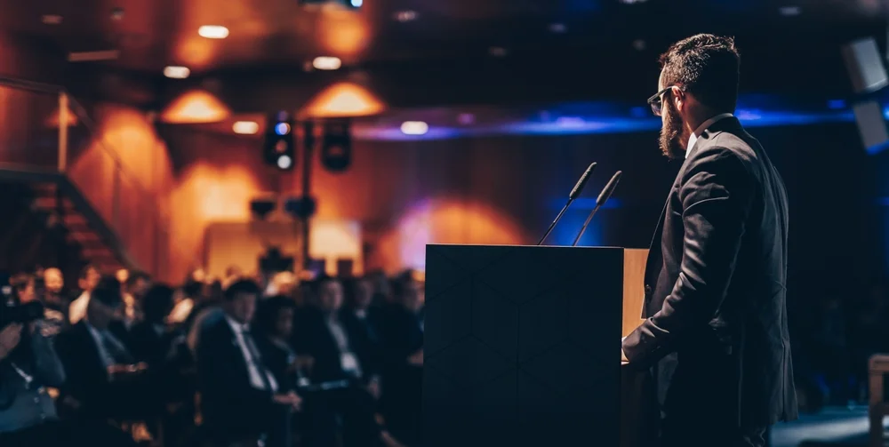 Speaker giving a talk on corporate business conference unrecognizable people